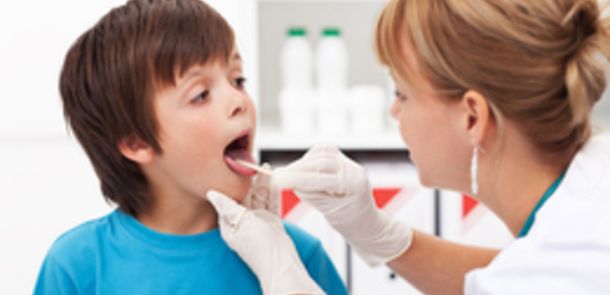 Ärztin untersucht den Rachen eines Kindes